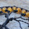 detailed  view of orange glass beads and black seed beads that help create this halloween style tree of life